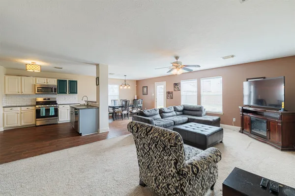 a living room with furniture kitchen view and a fireplace