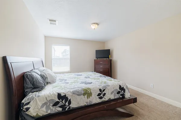 a bedroom with a bed and a tv