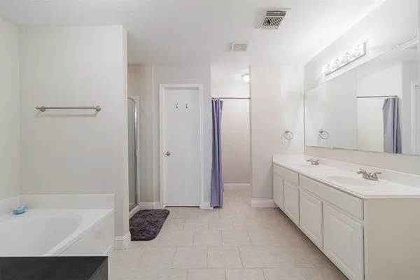 a bathroom with a tub sink and mirror