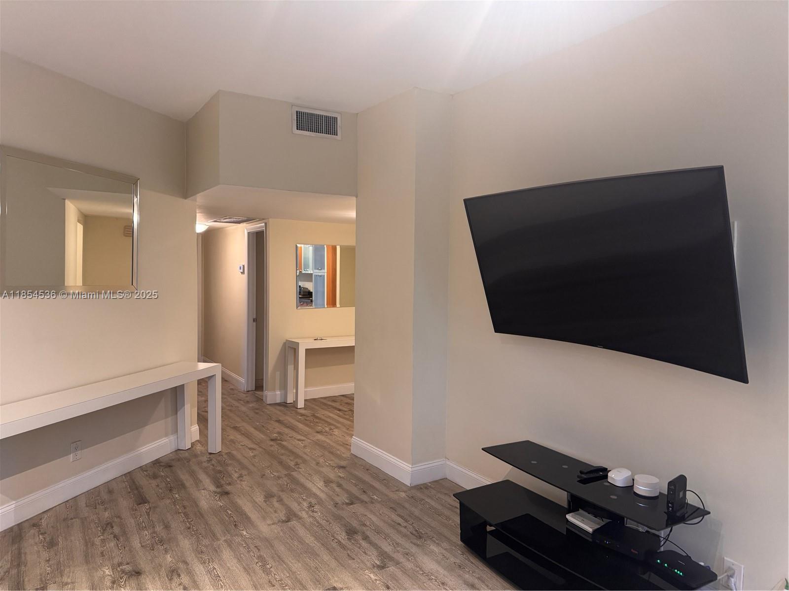 1121 Crandon Boulevard, Unit E108 Key Biscayne, FL 33149 - Photo 15 of 54 a living room with furniture and a flat screen tv