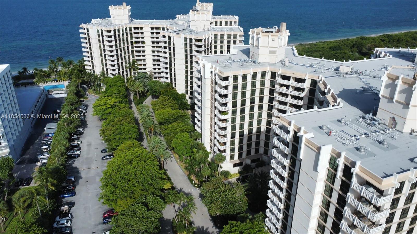 1121 Crandon Boulevard, Unit E108 Key Biscayne, FL 33149 - Photo 44 of 54 an aerial view of a residential apartment building with a yard and plants