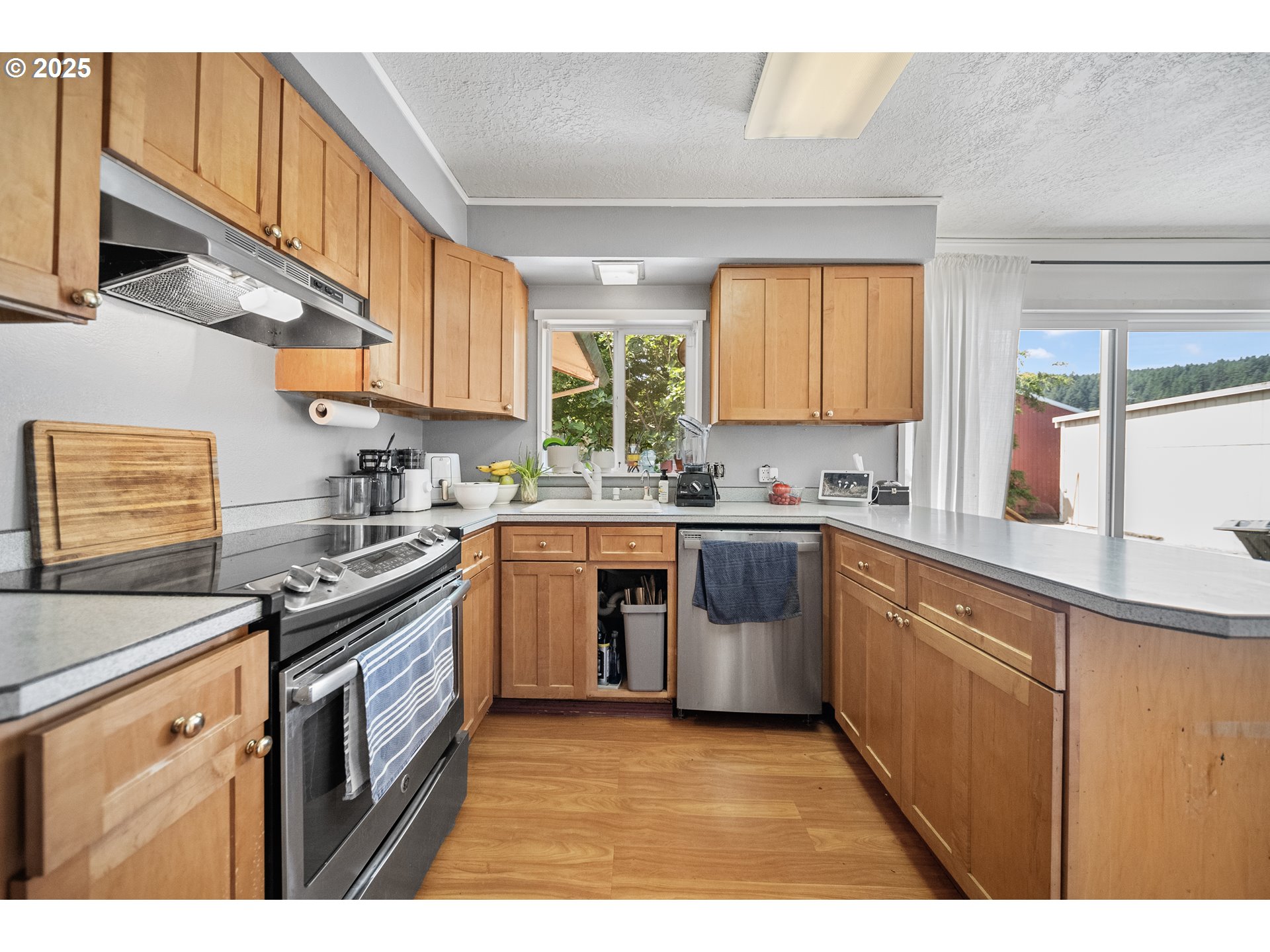 15317 South Hattan Road Oregon City, OR 97045 - Photo 10 of 44 a kitchen with stainless steel appliances granite countertop a stove a sink and a microwave