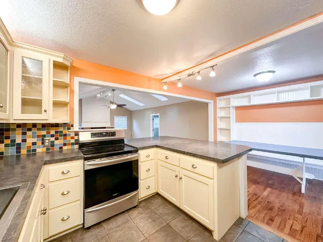 a kitchen with granite countertop a stove top oven sink and cabinets