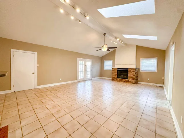 a view of empty room with a fireplace and window