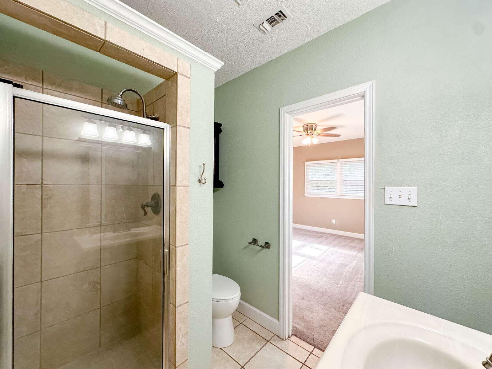 2614 32nd Street Lubbock, TX 79410 - Photo 29 of 37 a bathroom with a granite countertop toilet a sink and shower