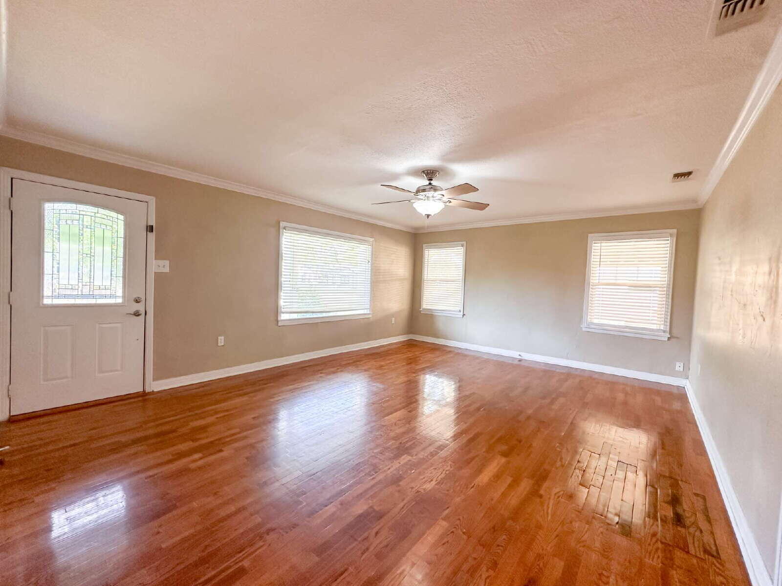 2614 32nd Street Lubbock, TX 79410 - Photo 4 of 37 a view of an empty room with wooden floor and a window