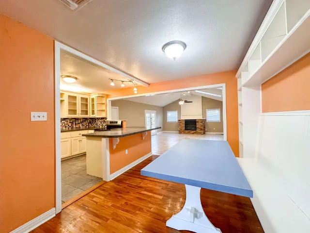 a room with stainless steel appliances kitchen island granite countertop a sink and cabinets