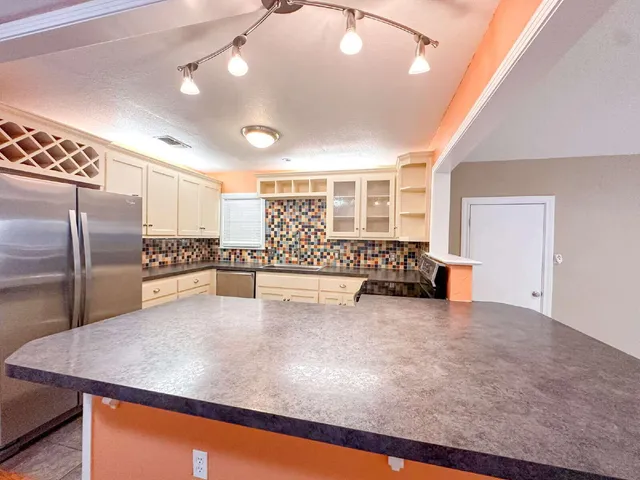 a view of kitchen with furniture and refrigerator