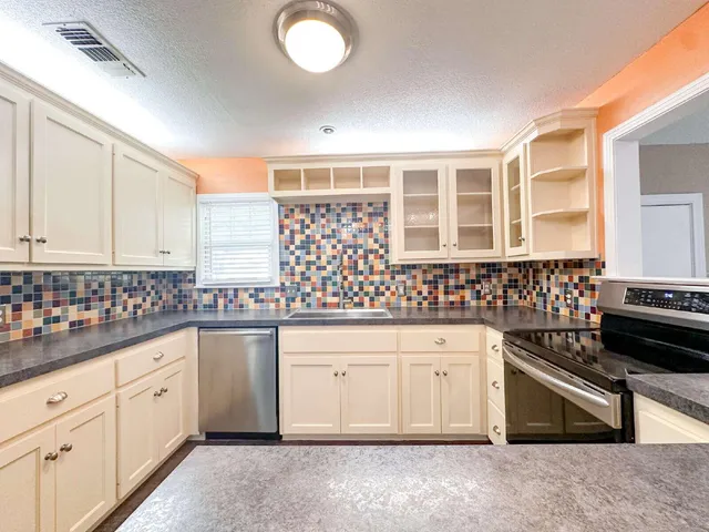 a kitchen with granite countertop a sink and cabinets