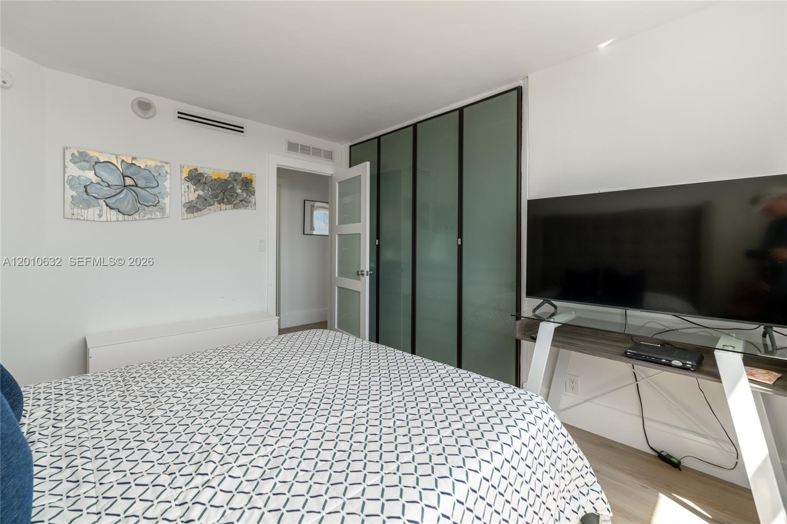 2639 North Riverside Drive, Unit 501 Pompano Beach, FL 33062 - Photo 22 of 39 a bedroom with a bed and a flat screen tv
