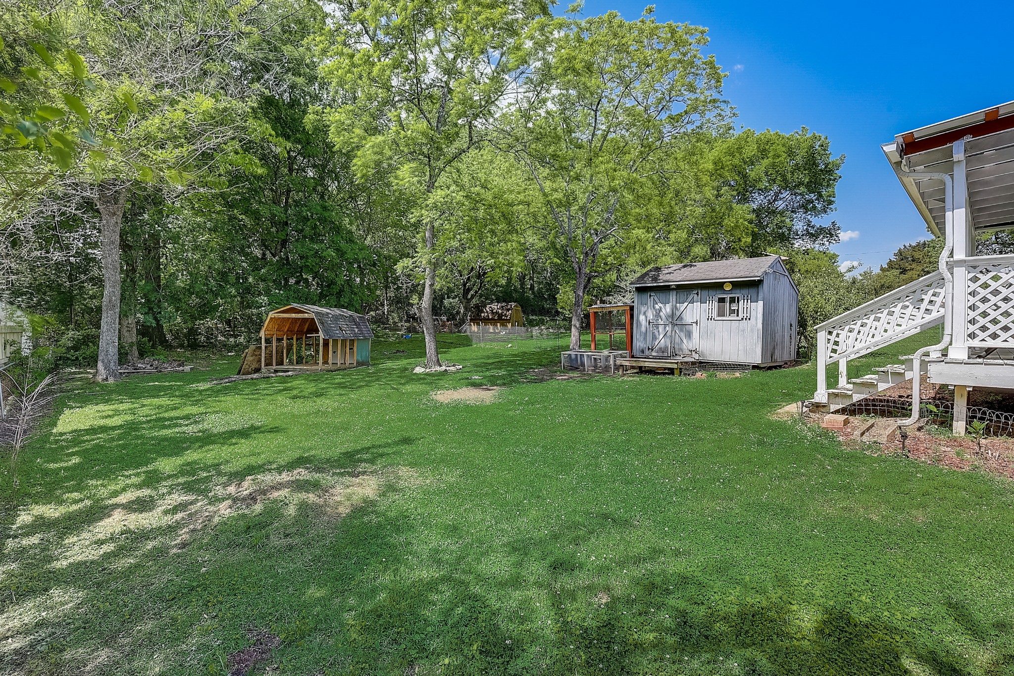 248 Manzano Road Madison, TN 37115 - Photo 25 of 27 a view of a backyard with table and chairs and a small barn