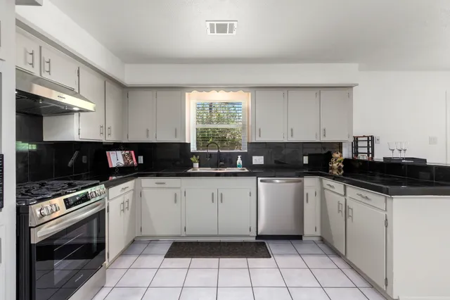 a view of a kitchen with a sink and a refrigerator