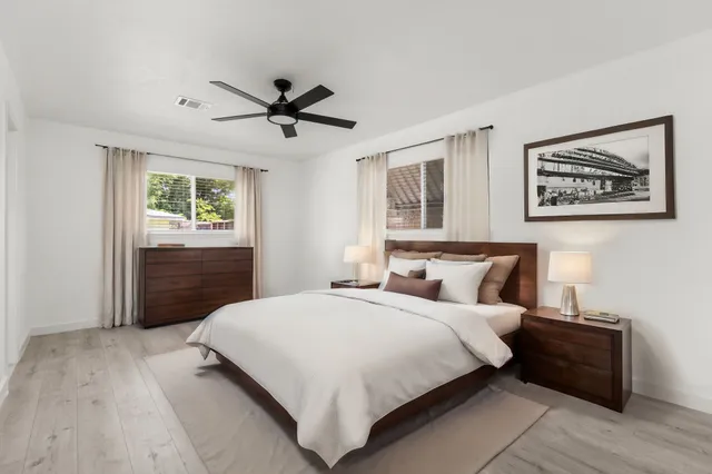 a view of empty room with wooden floor and ceiling fan