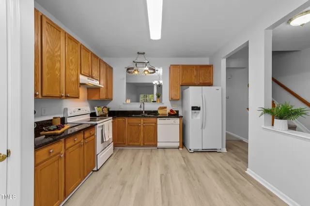 a kitchen with a stove a sink and a window