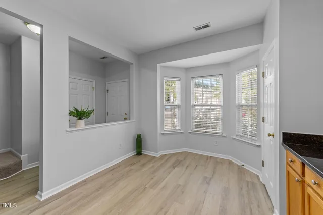 a kitchen with stainless steel appliances granite countertop a stove a sink dishwasher and a refrigerator with wooden floor