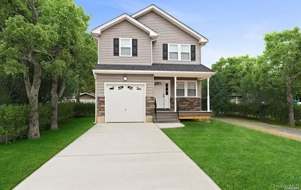 a front view of a house with a yard and trees