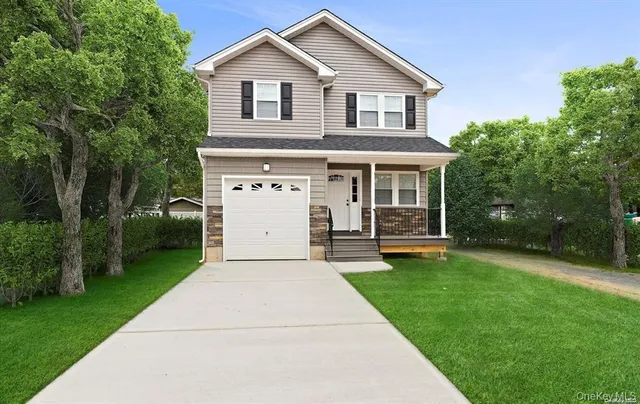 a front view of a house with a yard and trees