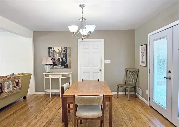 a view of a dining room with furniture wooden floor and a chandelier
