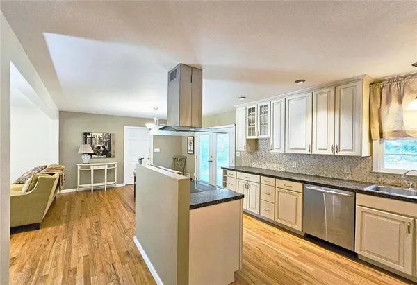 a kitchen with kitchen island granite countertop lots of counter top space and stainless steel appliances