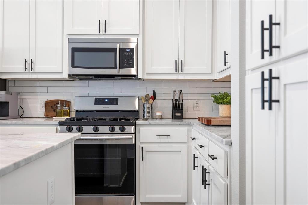 312 North Henderson Avenue, Unit 1 Dallas, TX 75214 - Photo 13 of 25 a kitchen with stainless steel appliances granite countertop a stove a sink and a microwave