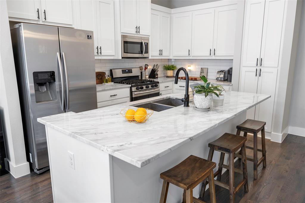 312 North Henderson Avenue, Unit 1 Dallas, TX 75214 - Photo 14 of 25 a kitchen with stainless steel appliances granite countertop a table chairs and refrigerator