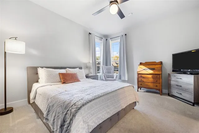 a bedroom with a bed and a flat tv screen on dresser
