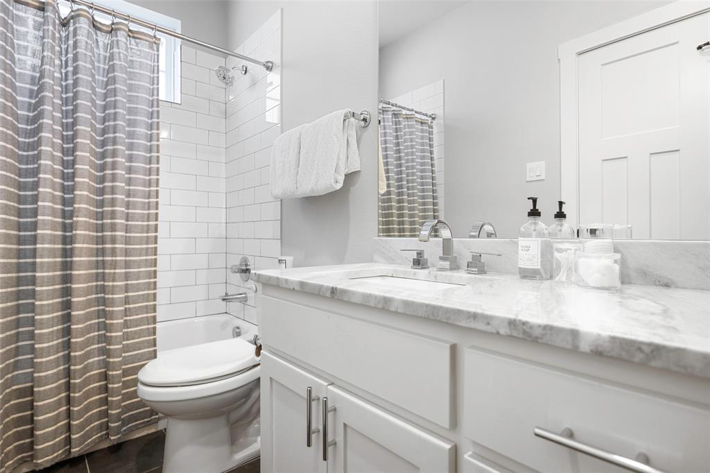 312 North Henderson Avenue, Unit 1 Dallas, TX 75214 - Photo 22 of 25 a bathroom with a granite countertop toilet sink and mirror