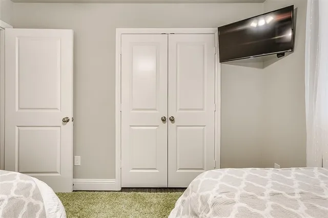 a view of bedroom with wooden floor and flat screen tv