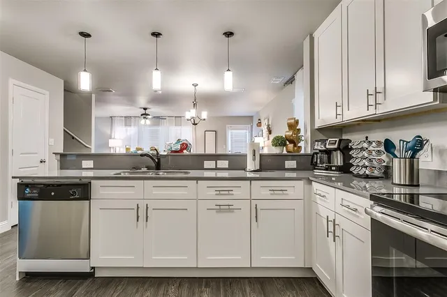 a kitchen with white cabinets and white appliances