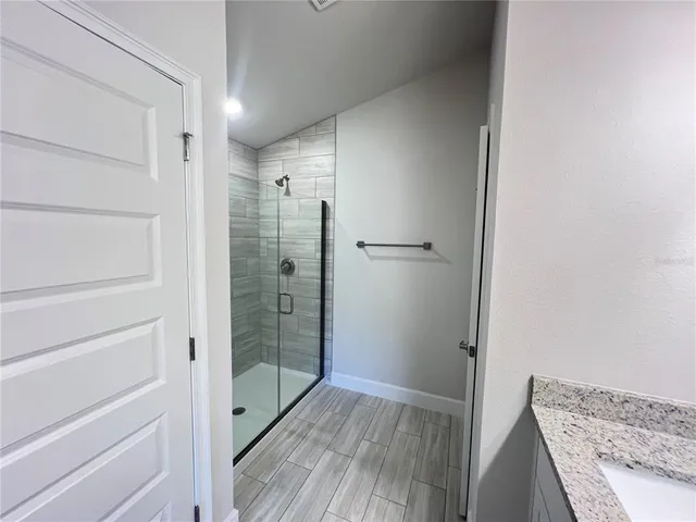 a bathroom with a shower and a glass door