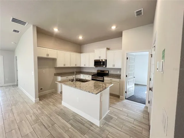 a kitchen with a sink refrigerator and cabinets