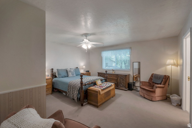 11072 Windy Peak Ridge Drive, Unit 32 Sandy, UT 84094 - Photo 15 of 30 Carpeted bedroom featuring a ceiling fan with integrated lighting, a window with blinds, and white walls with a wainscoting detail
