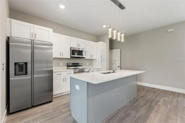 a kitchen with kitchen island a sink stainless steel appliances and cabinets