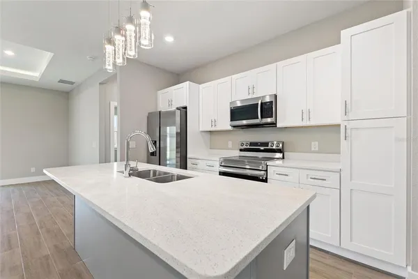 a kitchen with stainless steel appliances a stove refrigerator sink and microwave
