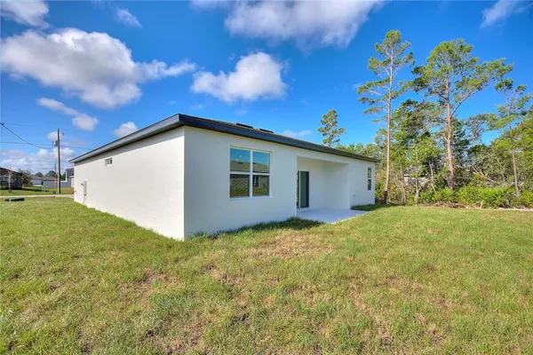 a backyard of a house with lots of green space and garden