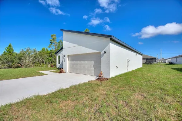 a view of a house with backyard and a garage