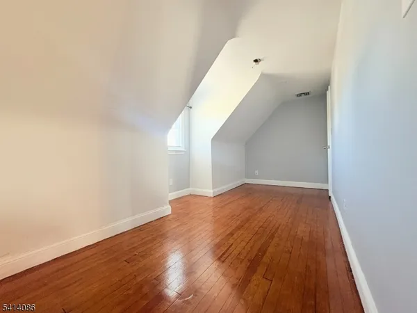 a view of a room with wooden floor and white walls