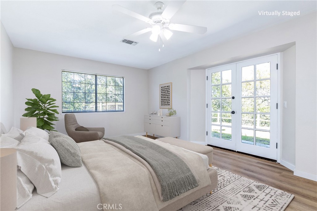 10870 Santa Ana Road Atascadero, CA 93422 - Photo 30 of 67 The primary suite is located on the main floor and has vinyl plank flooring and a French door. Photo has been virtually staged.