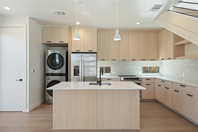 a kitchen with kitchen island white cabinets stainless steel appliances a sink and a counter top space