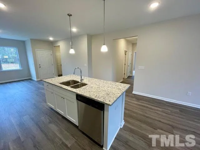 a kitchen with a sink and wooden floor