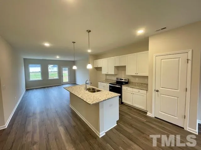 a kitchen with a sink and wooden floor