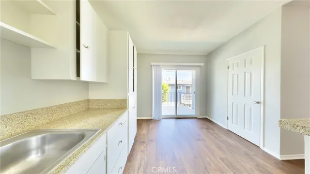 a view of a kitchen with a sink and wooden floor