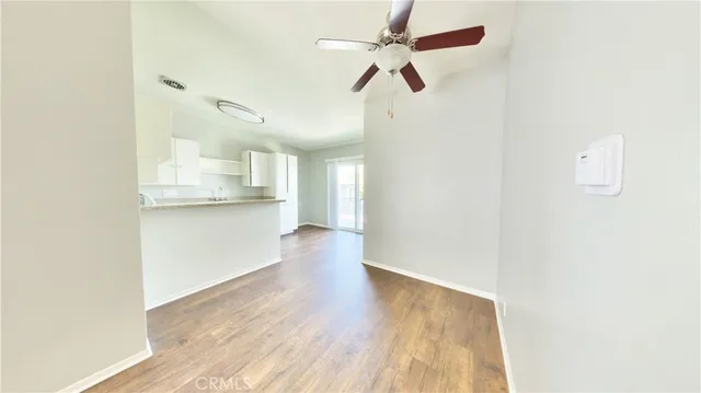 a view of a kitchen with wooden floor and a ceiling fan