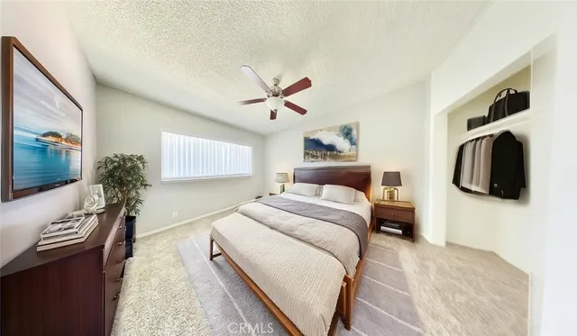 a bedroom with a large bed and a flat tv screen on a dresser