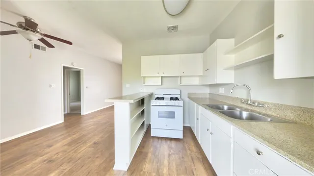 a kitchen with a sink a stove and cabinets