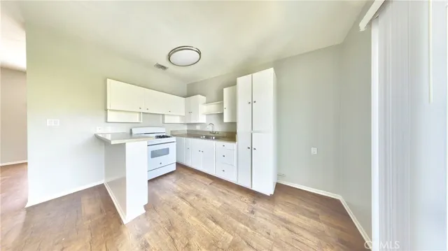 a kitchen with white cabinets and white appliances