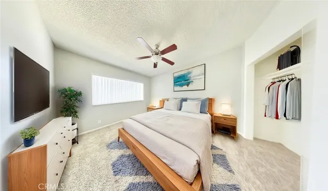 a spacious bedroom with a bed and a flat screen tv