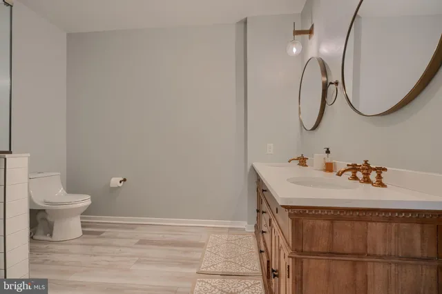 a bathroom with a sink vanity mirror and toilet