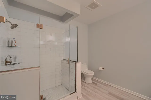 a bathroom with a granite countertop toilet and a shower