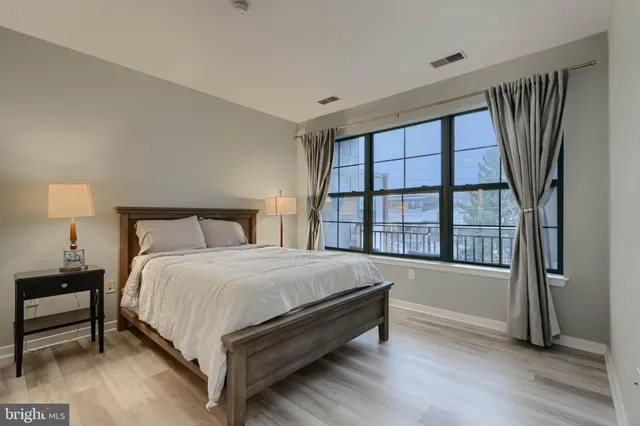 a large bed sitting in a bedroom next to a window